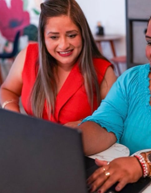 Dos mujeres trabajando juntas frente a una computadora