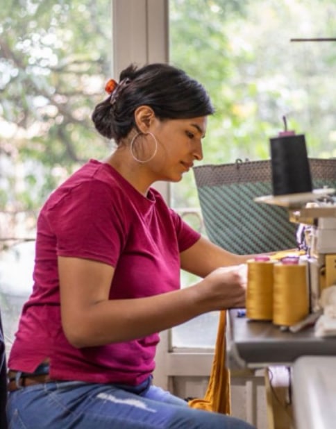 Mujer cosiendo en un taller textil
